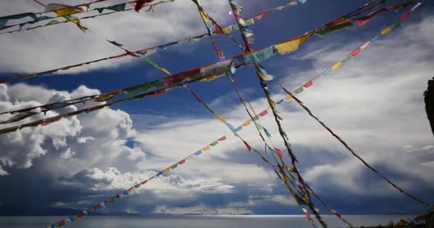 4k enorme masa de nubes rodando sobre el lago namtso & montaña de nieve, rezar bandera en el viento . — Vídeo de stock