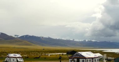 Tibet Gölü namtso, çoban çadır, inek bir grup üzerinde inişli çıkışlı 4 k bulutlar yığın.
