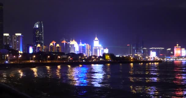 4k video, Edificio urbano junto al mar por la noche, Tsingtao, QingDao, China . — Vídeos de Stock