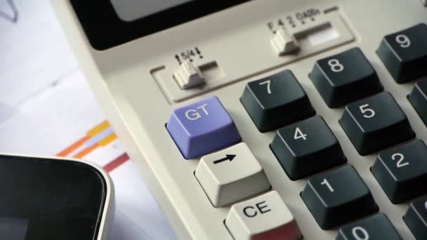 Обертання калькулятора та планшетного ПК з діаграмою бізнес-графіків на столі . — стокове відео