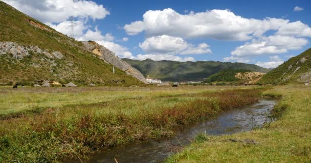 4k Fluss in der Prärie, Wolkenmassen rollen über Berge, weit entfernter Tempel. — Stockvideo