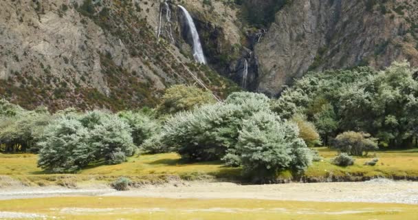 4k Wasserfall, der im Tal fließt, Busch auf der Nahrung des Berges in Tibet. — Stockvideo