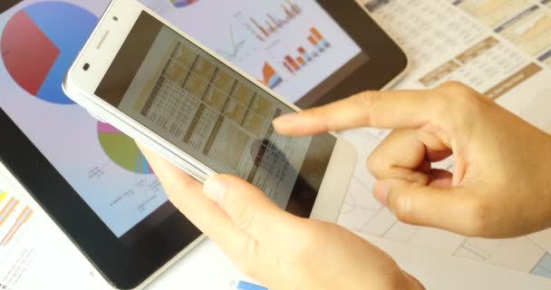 4k Les gens d'affaires naviguant sur les données financières sur SmartPhone & ipad . — Video