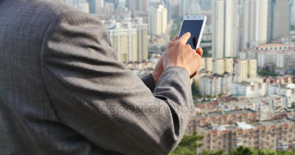 4 k affärsman med en smartphone mot modern urban byggnad bakgrund. — Stockvideo