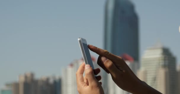 4k Человек, использующий смартфон аганист современный бизнес-здания фон . — стоковое видео