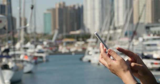 4 k A flicka med en smartphone på seaside, yacht & segling i hamnen. — Stockvideo