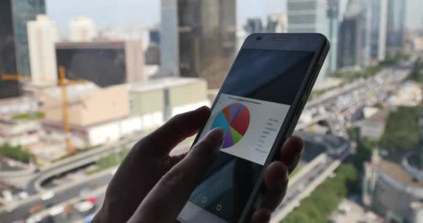 4k, Geschäftsmann Browsen Geschäftsformulare Diagramm auf Smartphone, Gebäude, Verkehr. — Stockvideo