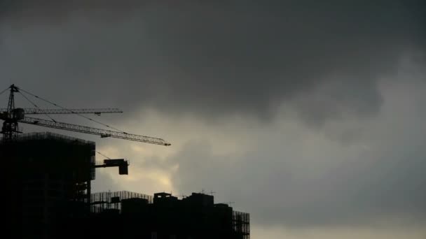 Nuages sombres couvrent ciel ensoleillé, bâtiment de grande hauteur, silhouette de la maison . — Video