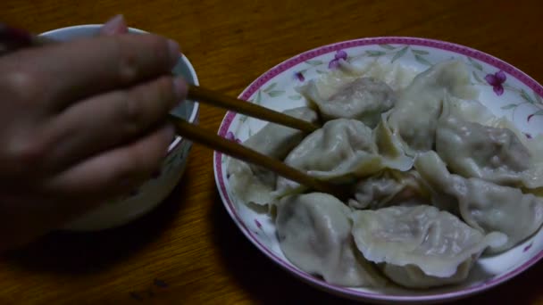 Usar pauzinhos comendo bolinhos, tradição chinesa ano novo comida deliciosa . — Vídeo de Stock