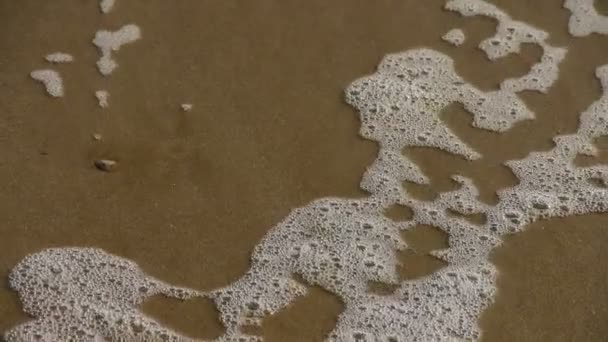 Olas en la playa de arena, burbujas y ampollas en la arena . — Vídeos de Stock