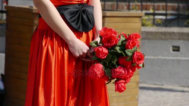 Mariée portant une robe de mariée rouge, portant un bouquet de fleurs roses . — Video