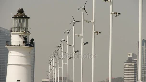 Latarnia morska i wiatr turbina & nowe miasto energii zasilania. — Wideo stockowe