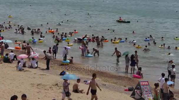 China-Ago 08,2016: Mucha gente en la concurrida playa de arena de baño.La gente nada en el mar, Qingd de China — Vídeos de Stock