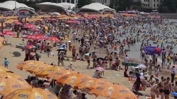 China-Ago 08,2016: Mucha gente en la concurrida playa de arena de baño.La gente nada en el mar, Qingd de China — Vídeos de Stock