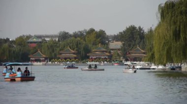 Willow adada güvenerek Çin Pekin Beihai Park'ta gölde botla insanlar.