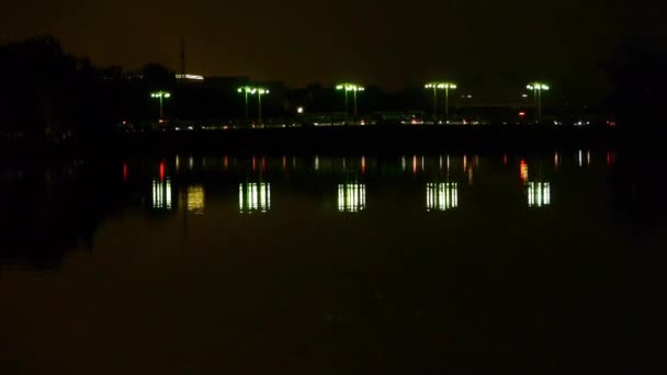Reflection on lake with busy traffic on bridge at night in Beijing China. — Stock Video