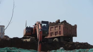 Çin-Eyl 08, 2016:Excavator çalışma ve damperli kamyon inşaat sitesinde.