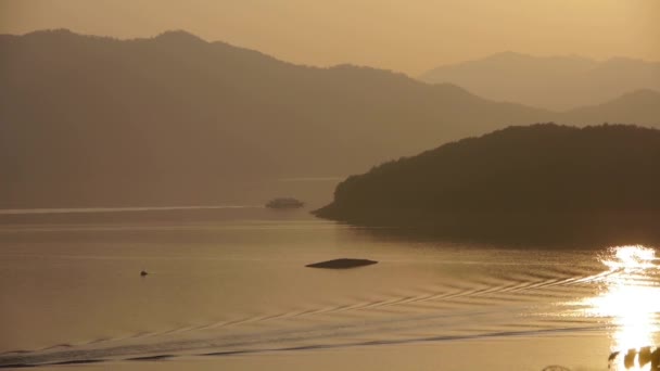 Захід сонця над островом та озером . — стокове відео