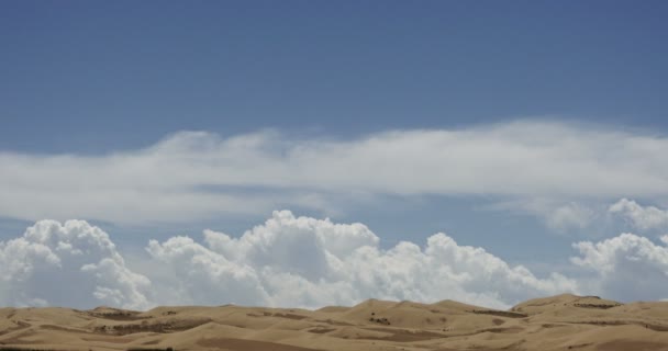 4k timelapse большие белые пухлые облака массы прокатки над песчаными дюнами пустыни . — стоковое видео