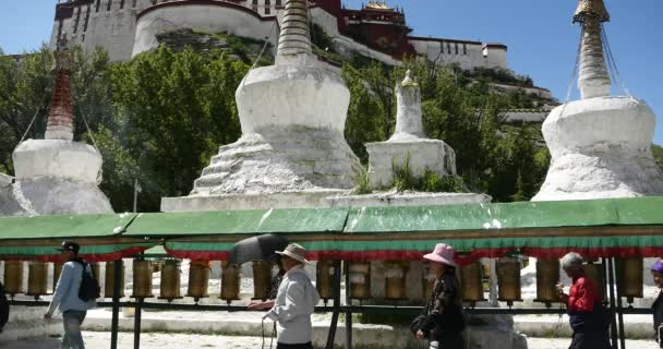 China-Aug 08,2016: 4k tibet pessoas giram girando rodas de oração budista, Potala & stupa branco . — Vídeo de Stock