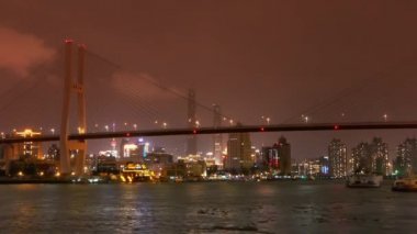 Timelapse, nehirde, deniz köprü üzerinden parlak kentsel nakliye meşgul bina.