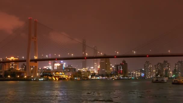タイムラプス、忙しい、明るい都市海橋を渡って川沿いに配送の構築. — ストック動画