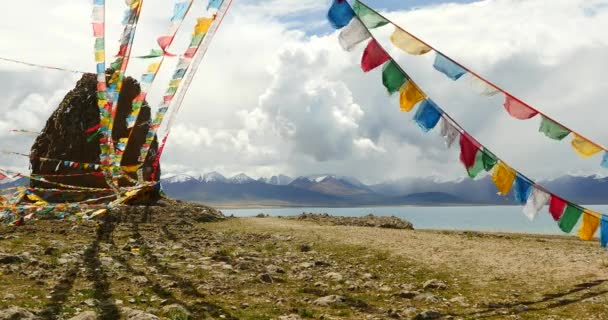 4k huge clouds mass rolling over lake namtso & snow mountain,pray flag in wind. — Stock Video