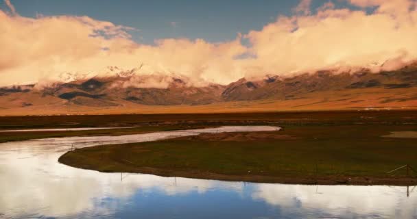 4 k timelapse wolken massa voortschrijdend over Tibet berg, rivier stroomt de prairie. — Stockvideo