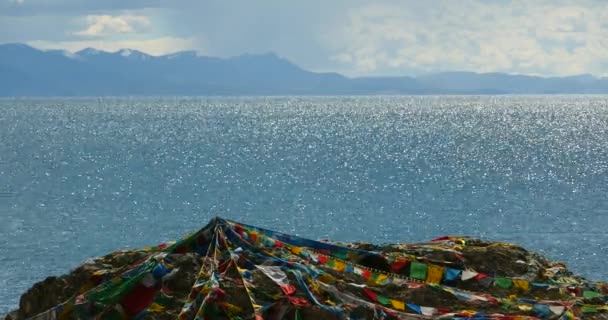 4k riesige Wolkenmassen rollen über den namtso-see & schneeberg, beten fahne im wind. — Stockvideo