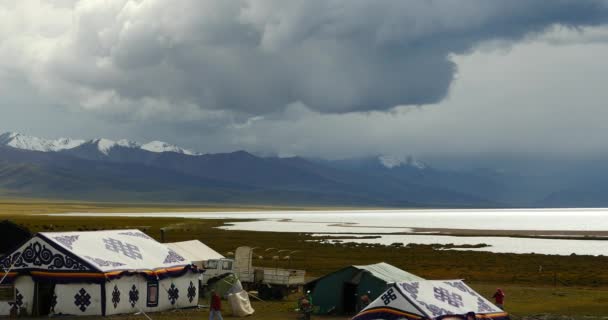 4k masa de nubes rodando sobre el lago Tíbet namtso, tienda de pastores, un grupo de vacas . — Vídeos de Stock