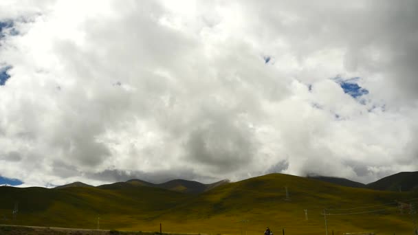 4k clouds mass rolling over Tibet mountain,tibetan driving motorcycle. — Stock Video