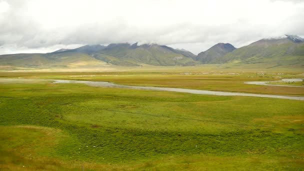 4k Wolkenmasse rollt über den Tibet-Berg, Fluss fließt durch die Prärie. — Stockvideo