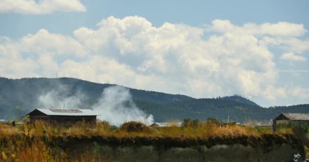 4k queimar fumaça & tibetan-casas, nuvens sobre montanhas em Shangri-La yunnan . — Vídeo de Stock