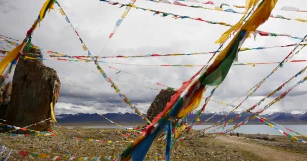 4 k enorme wolken massa kantelen meer namtso & sneeuw berg, bidden vlag in de wind. — Stockvideo