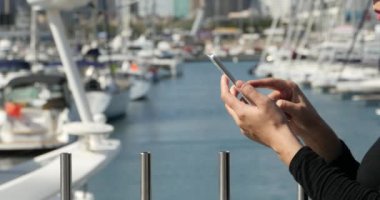 sahil, yat ve yelken ve liman, bir akıllı telefon kullanan 4 k A kız.