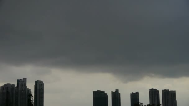 Dunkle Wolken bedecken den Sonnenhimmel, Hochhaus, Haussilhouette.