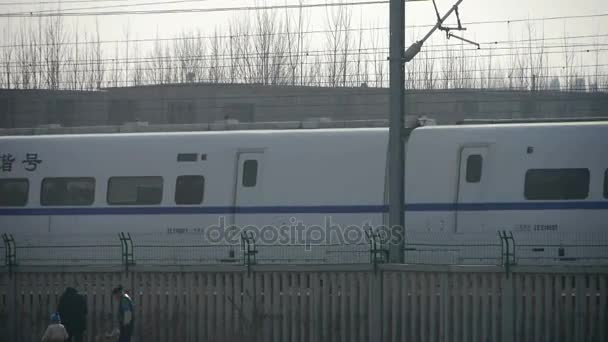 White high-speed train between the wire,People in railway side. — Stock Video