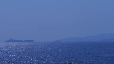 Kargo gemisi hareket üzerinde köpüklü dalgalar.