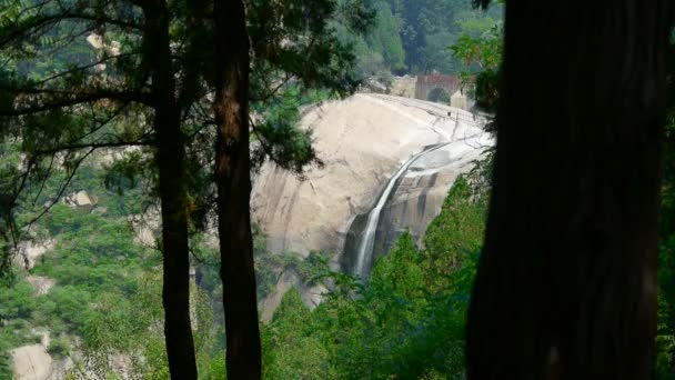 Berg vattenfall ström till pool från flera lager sten, skogar och buskar. — Stockvideo