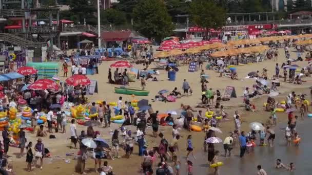 China-Ago 08,2017: Mucha gente en la concurrida playa de arena de baño.La gente nada en el mar, Qingd de China — Vídeos de Stock