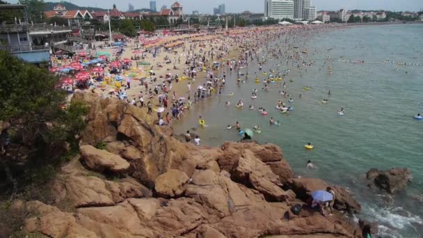 Китай-Серпень 08, 2017:People плавати в морі, багато людей в переповненому купання піщаний пляж. Панорамний з — стокове відео
