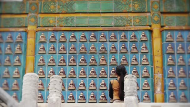 Chiny-wrzesień 08, 2017:tourist wyglądać starożytnego Wschodu Buddy totem ściany. — Wideo stockowe