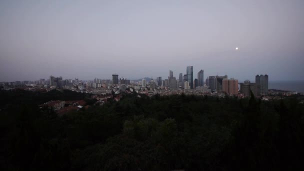 Lasso di tempo di luna che sorge sopra lo skyline urbano, da giorno a notte . — Video Stock