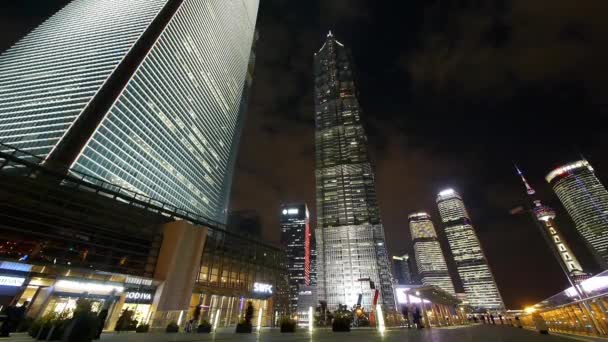 Lapso de tiempo, peatonal ocupado pasando shanghai huanqiu rascacielos por la noche . — Vídeo de stock