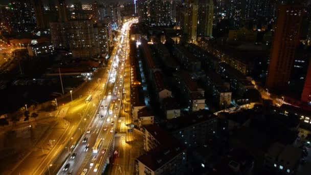 Atasco de tráfico urbano ocupado por la noche, fondo del edificio morden urbano brillantemente iluminado . — Vídeo de stock