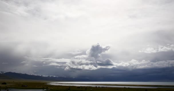 4k masa de nubes rodando sobre el lago Tíbet namtso, tienda de pastores, un grupo de vacas . — Vídeo de stock