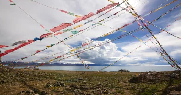 4k enorme masa de nubes rodando sobre el lago namtso & montaña de nieve, rezar bandera en el viento . — Vídeo de stock