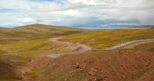 4k coche de conducción en el camino meandro, la distancia lago namtso & montaña en el Tíbet . — Vídeo de stock