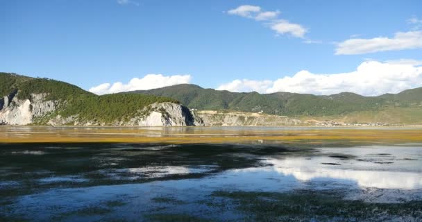 4k nubes masa rodando sobre las montañas reflejan en el lago, Shangri-La yunnan, china . — Vídeo de stock