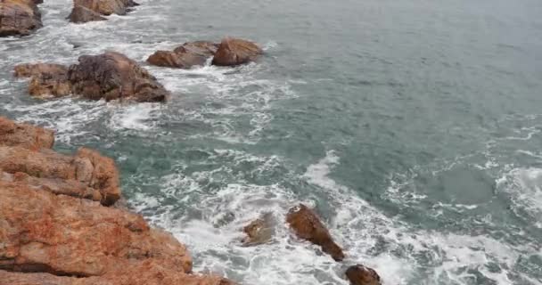 4k искры океанских волн морской воды на поверхности и прибрежных скалистых берегах . — стоковое видео